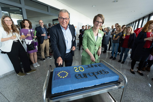 Peter Thiele, BMBF, und Franziska Bopp, NEC, schneiden die Europass-Geburtstagstorte an