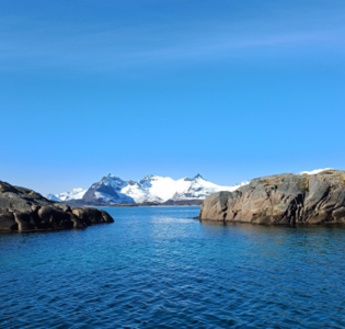Landschaft der Lofoten mit schneebedeckten Bergen und Meer